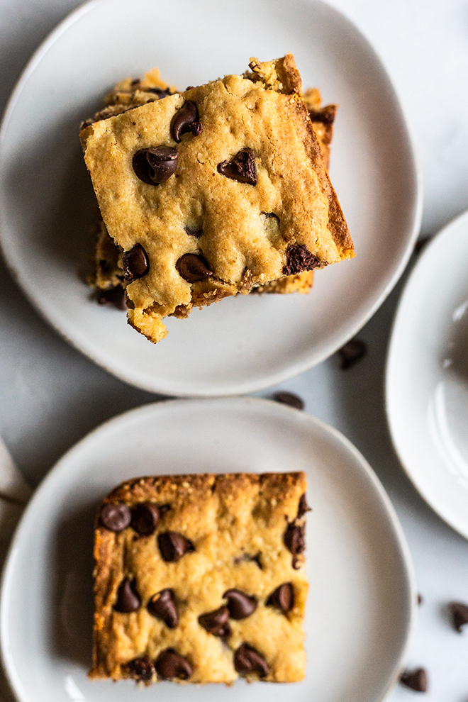 chocolate chip cookie bars on plates and a white background 