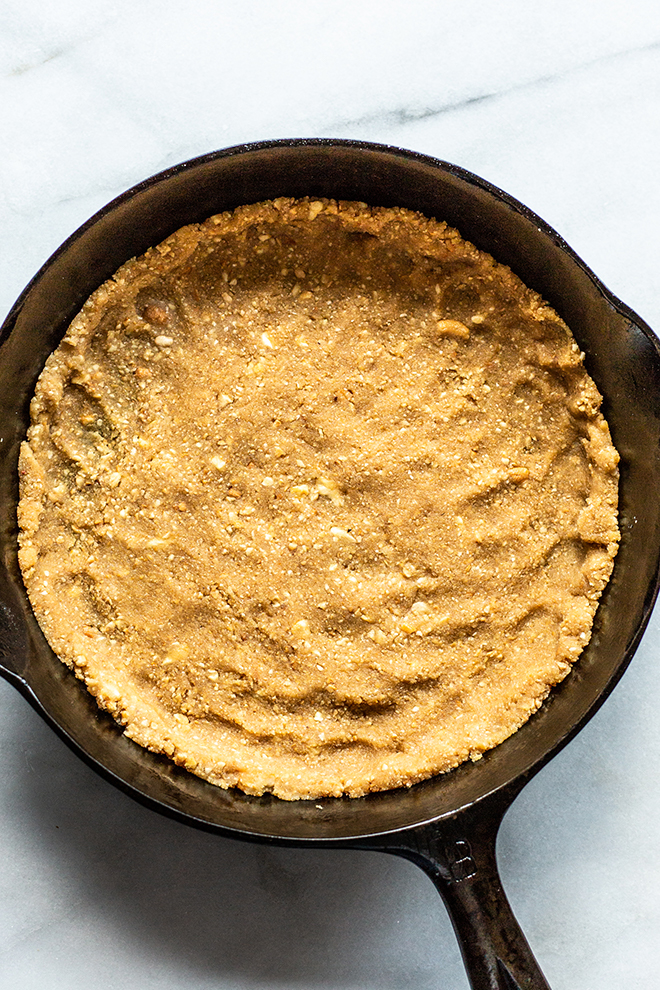 whole30 cashew crust in a skillet pan on a white background for a taco pie