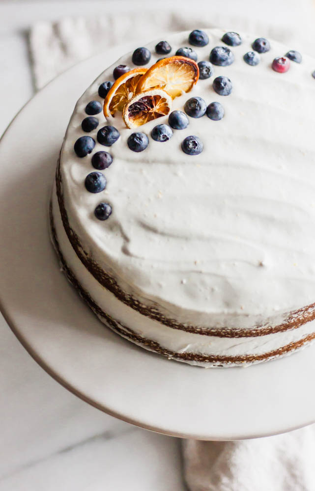 Moist, dairy free lemon blueberry cake made with healthier ingredients and topped with my favorite lemon coconut cream icing.