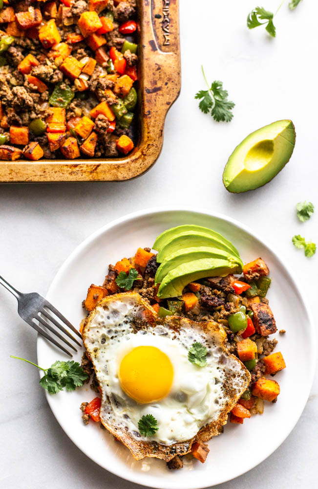 Looking for a better for you hash for breakfast (or whenever)? This Whole30 Bison Sweet Potato Hash has crispy sweet potatoes and veggies, lean bison and the perfect blend of spices. You can top with fried eggs, avocado, and cilantro for the best brunch or breakfast. This lower carb version can be made with turkey, beef, or venison, too. You make it on the stovetop and crisp it in the oven for the perfect potato. This recipe is #whole30approved and #paleo. #healthy #healthyrecipe #paleofood #breakfast 