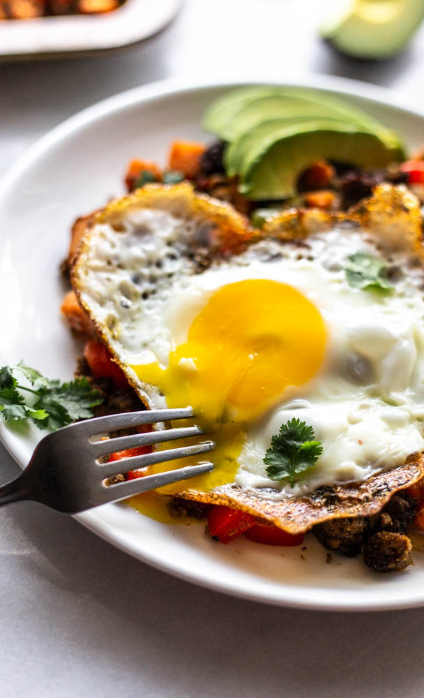 Looking for a better for you hash for breakfast (or whenever)? This Whole30 Bison Sweet Potato Hash has crispy sweet potatoes and veggies, lean bison and the perfect blend of spices. You can top with fried eggs, avocado, and cilantro for the best brunch or breakfast. This lower carb version can be made with turkey, beef, or venison, too. You make it on the stovetop and crisp it in the oven for the perfect potato. This recipe is #whole30approved and #paleo. #healthy #healthyrecipe #paleofood #breakfast 