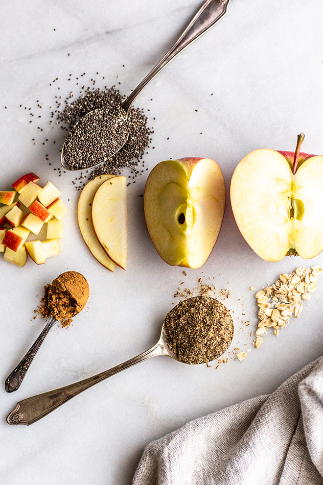 apples sliced and dices with chia seeds flax seeds and oats on a white background 