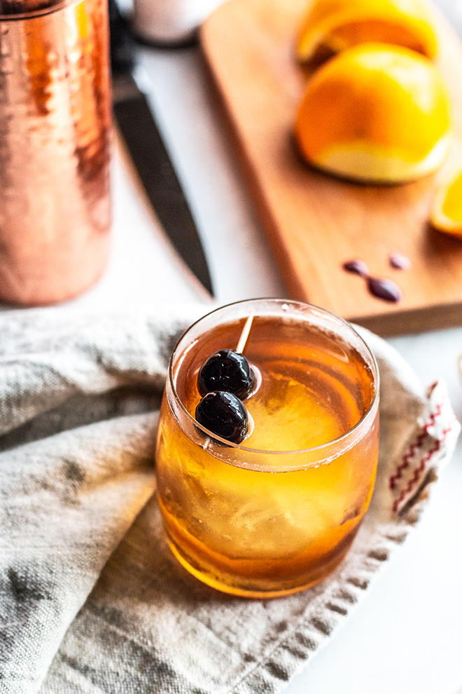 old fashioned cocktail with oranges and a copper shaker
