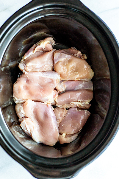 chicken thighs in a black slow cooker