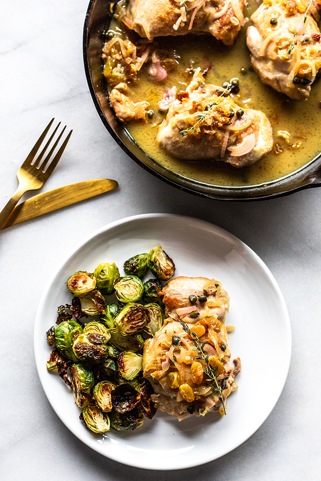 Juicy golden raisin glazed skillet chicken thighs pair perfectly with Brussels sprouts for an easy dinner that is crazy impressive. You won't believe the caramelized flavor on that chicken. 