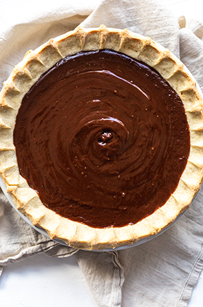 chocolate pie filling in a crust on a white background 