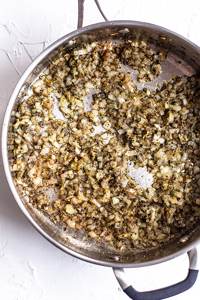 sautéed onions and garlic with herbs in a pan