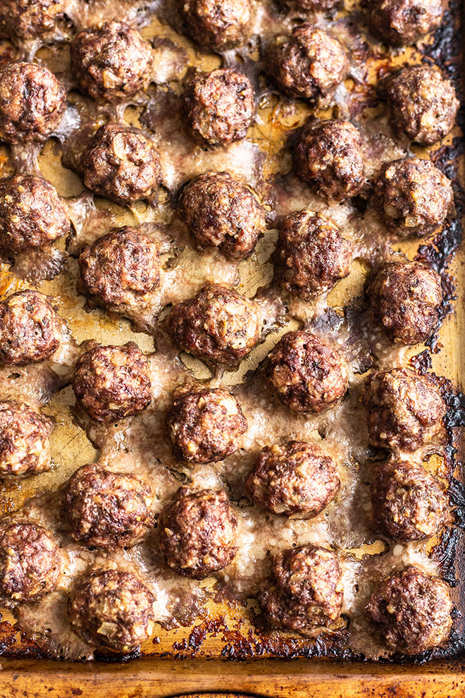baked meatballs on a gold baking sheet