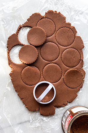 rolled out chocolate cookie dough cut out into circles 