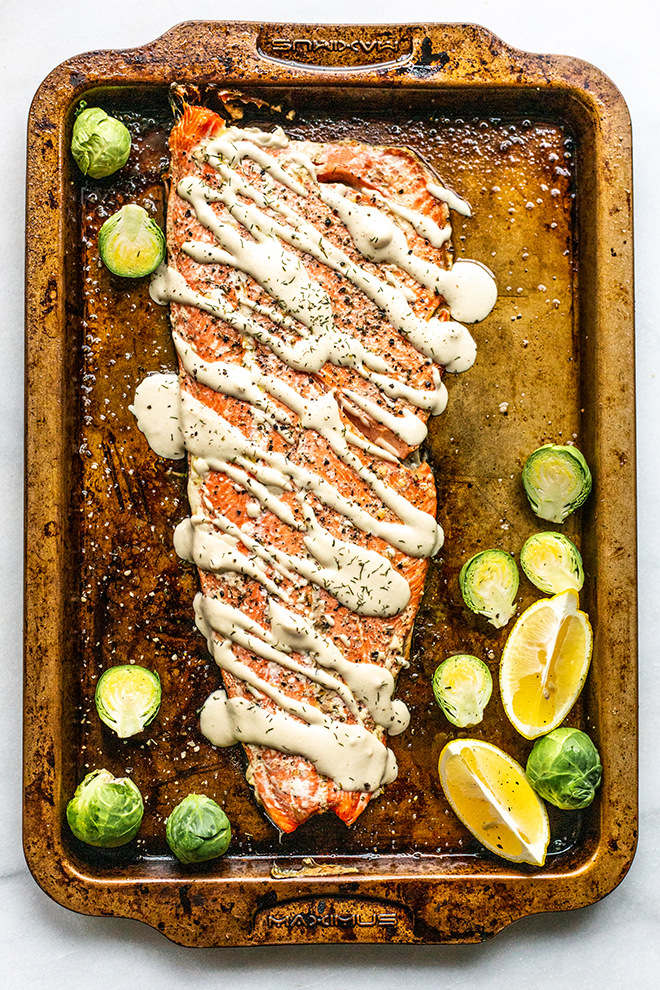 The easiest baked salmon is roasted whole on a sheet pan and topped with a quick lemon tahini sauce that's nutty, fresh and perfect for fish.