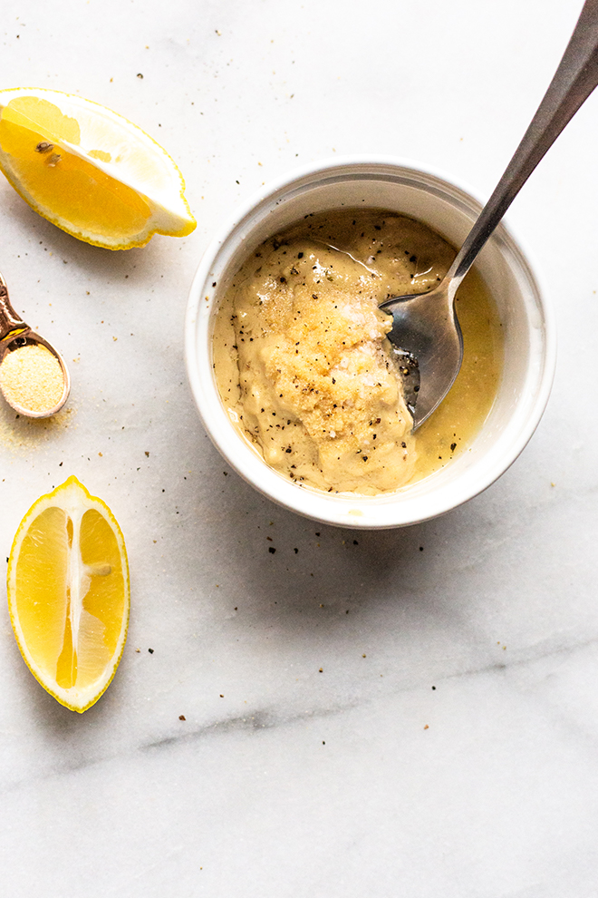 tahini in a white ramekin with lemon and garlic powder