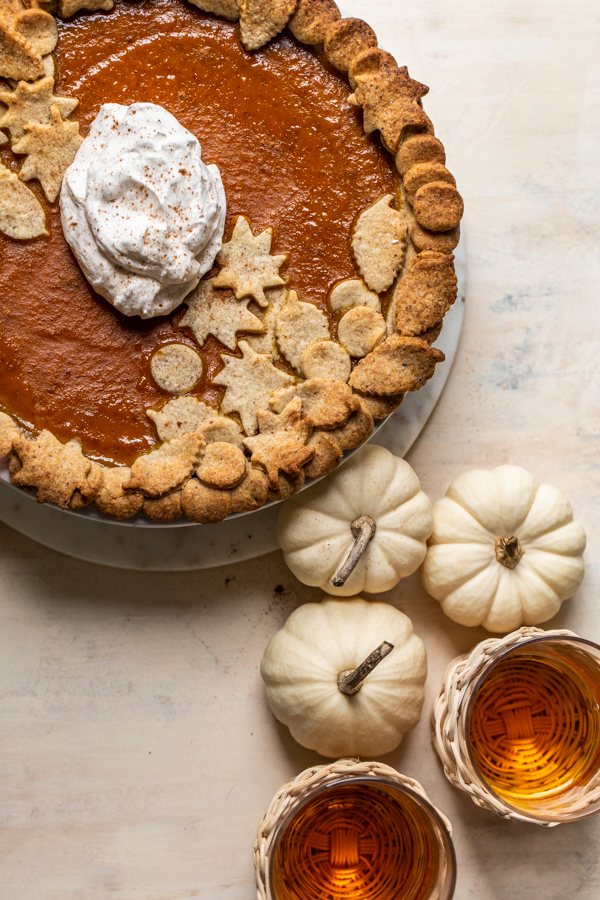 pumpkin pie with whipped cream and white pumpkins