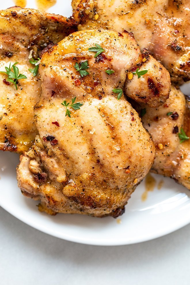 honey honey grilled chicken thighs stacked with parsley 