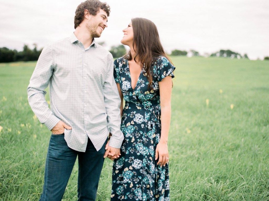 husband and wife in a field with blue outfits