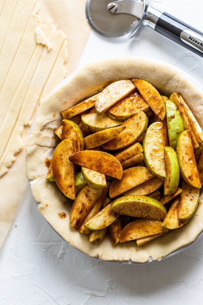 a lattice apple pie being made on a white background, unbaked