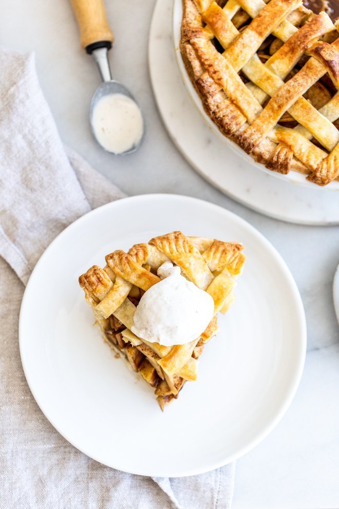 a slice of apple pie with ice cream on a white plate