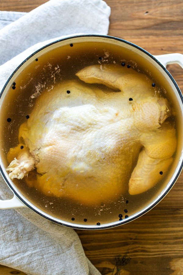 using a dutch oven to brine poultry on a wood table 