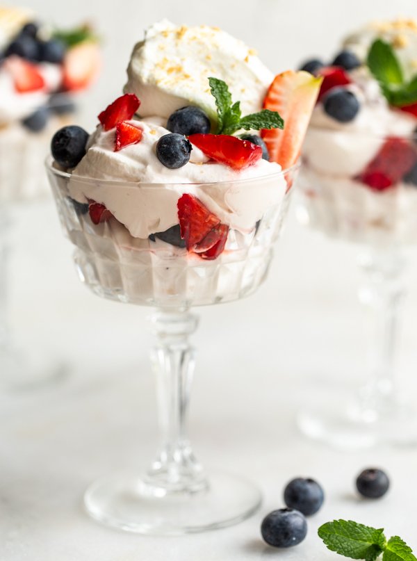 an easy, whipped berry fool dessert with fresh berries and mint in a sundae glass