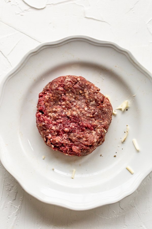 raw elk burger on a white plate