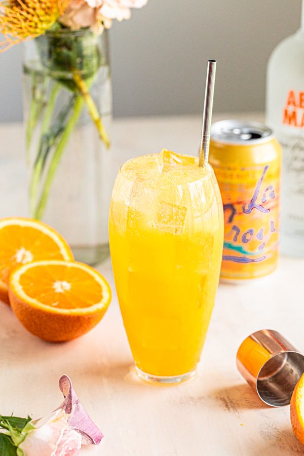 an orange crush in a clear tall glass
