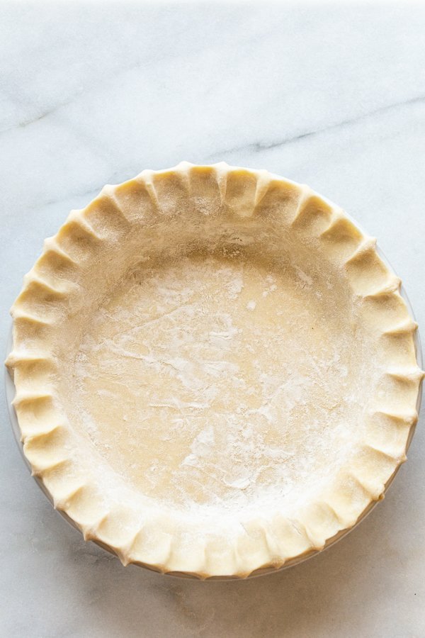 unbaked pie crust on a marble slab