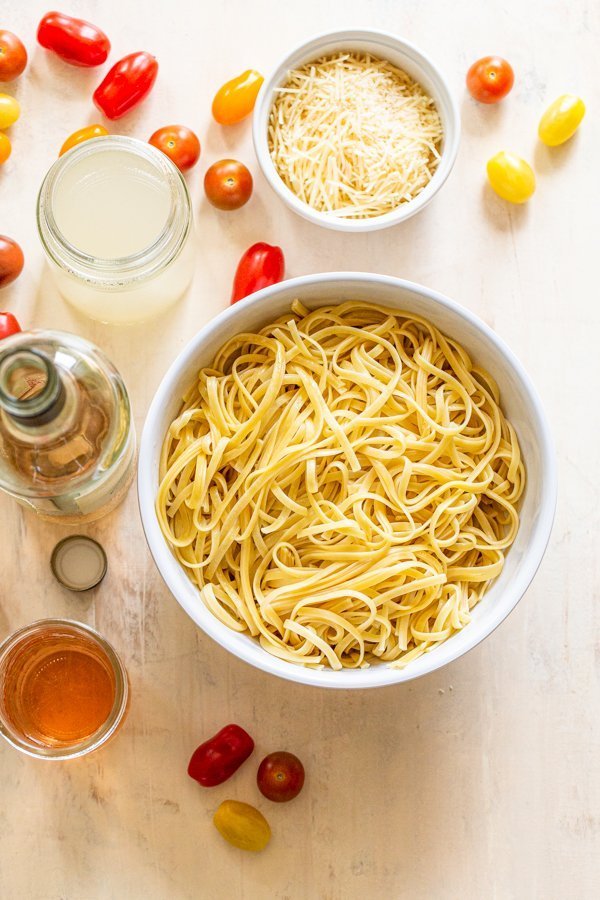 pasta in a bowl and all of the ingredients for a fresh tomato pasta dish