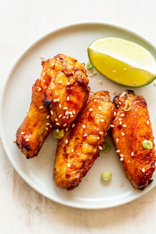 air fryer chicken wings on a cream plate with a lime