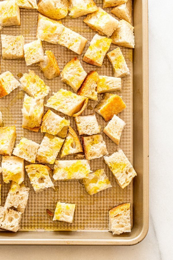bread cubes with olive oil on a baking sheet