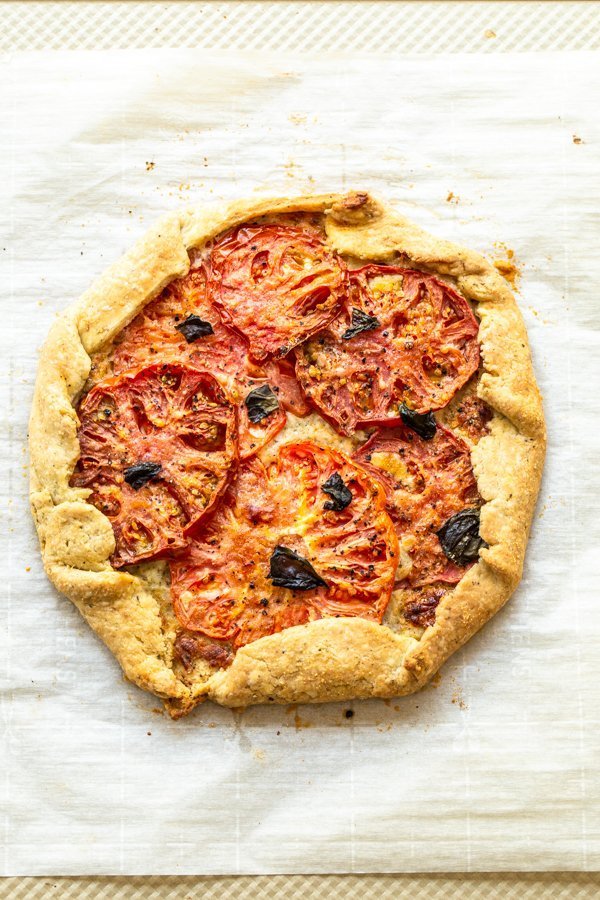 a tomato galette just out of the oven on parchment