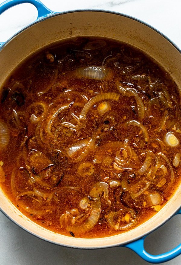 apple cider, onion, and golden raisins in a dutch oven