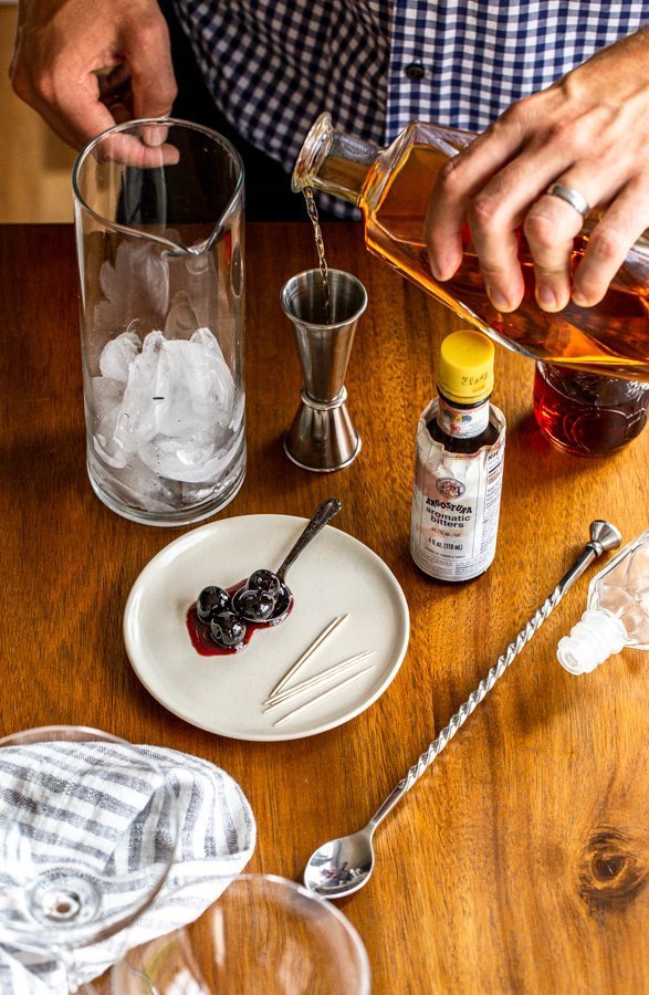 pouring bourbon into a cocktail jigger