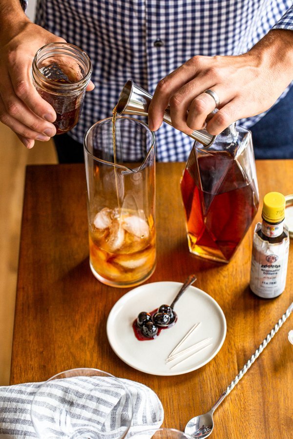 pouring vermouth into a cocktail pitcher