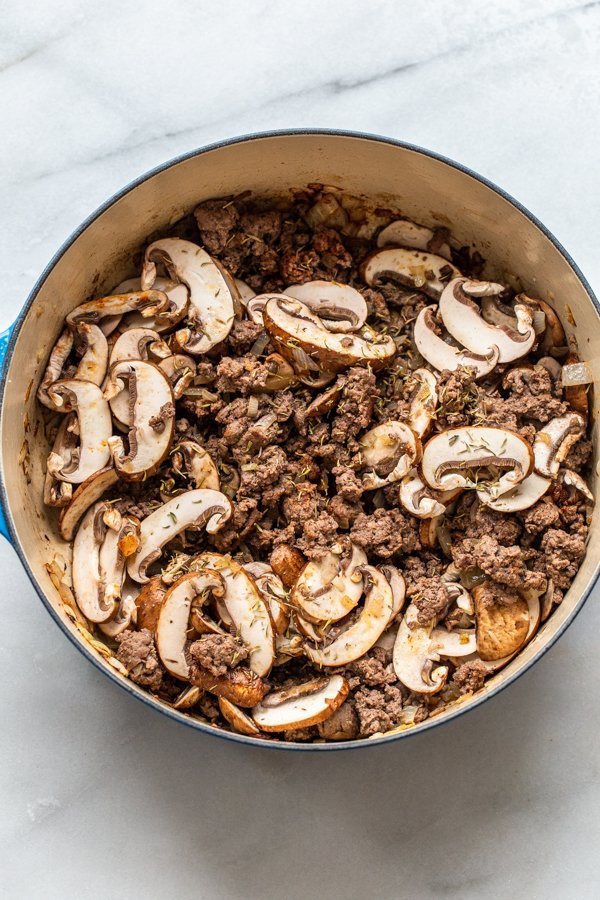 mushroom and ground venison cooking in a dutch oven