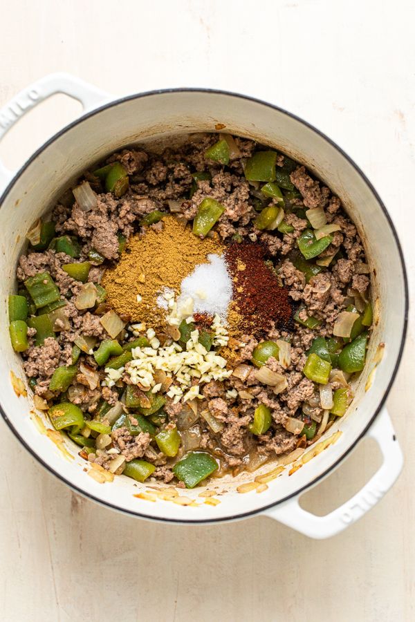 meat and peppers browned in a skillet with spices