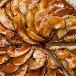 caramel apple tart with spices and sugar on a cream background