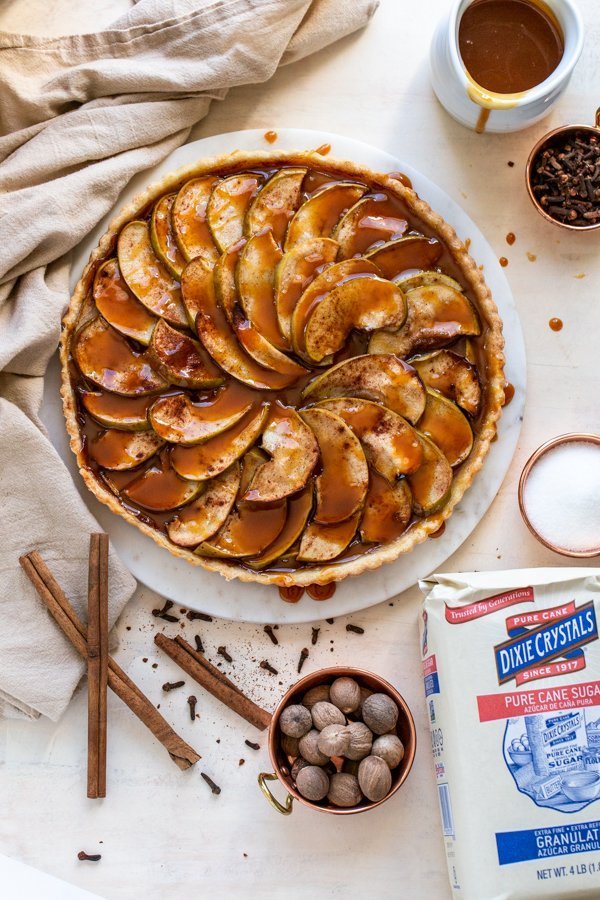 caramel apple tart with spices and sugar on a cream background