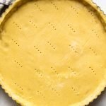 gluten free pie crust in a tart shell with a striped linen