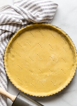 gluten free pie crust in a tart shell with a striped linen