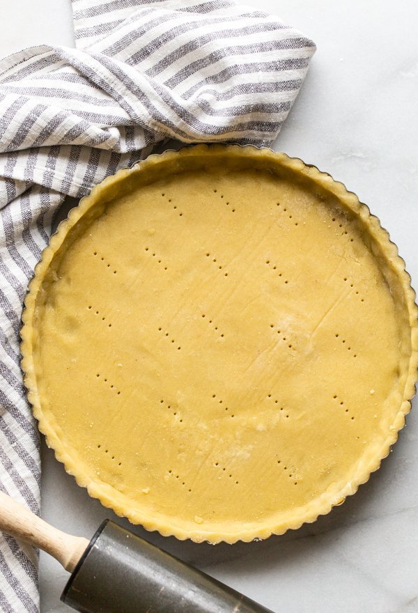 gluten free pie crust in a tart shell with a striped linen