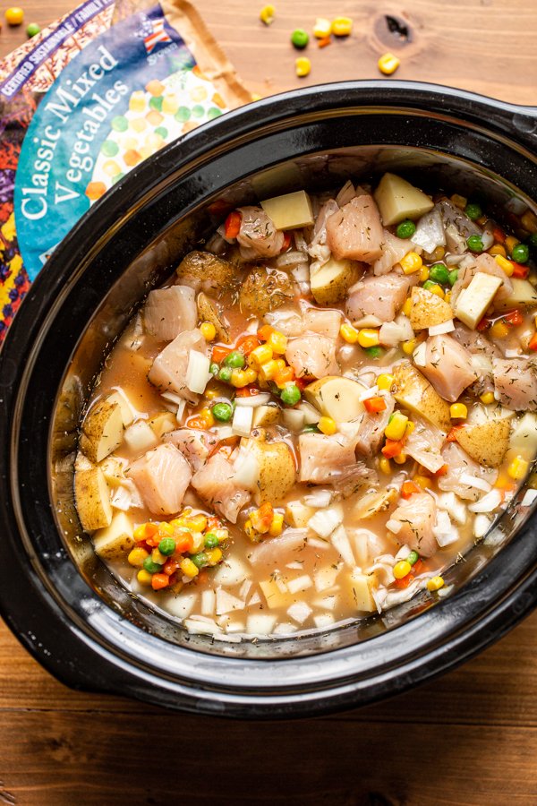 chicken soup in a black slow cooker