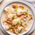 chicken corn chowder in grey bowls and a tan linen