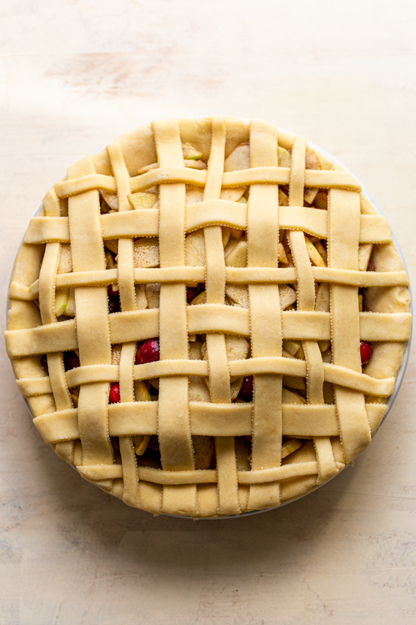 an unbaked lattice pie crust on a cream colored counter