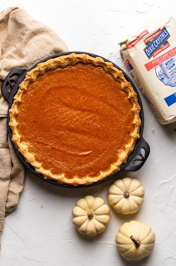 pie baked in black, cast iron pie dish with a bag of sugar