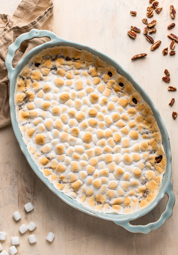 sweet potato casserole with marshmallows and pecans in a blue oval casserole dish