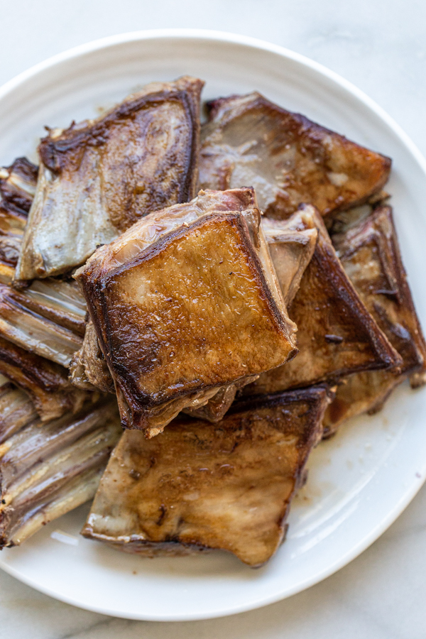 seared deer short ribs stacked on a platter