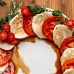 Caprese salad made into a wreath shape on a white plate