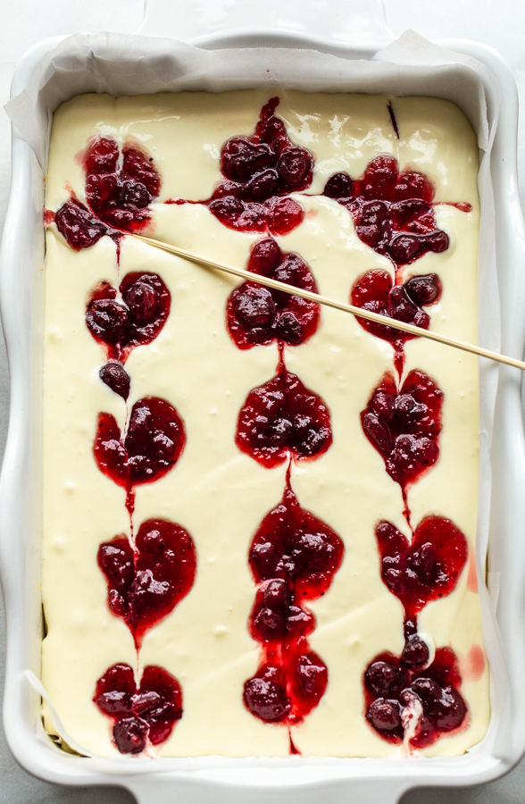 swirling cranberry sauce into unbaked cheesecake bar batter