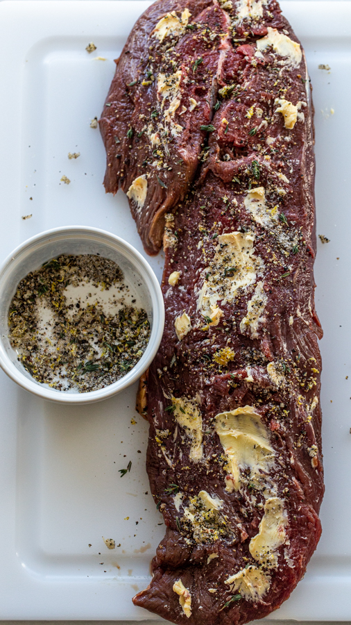 bison rubbed with butter and herbs on a cutting board