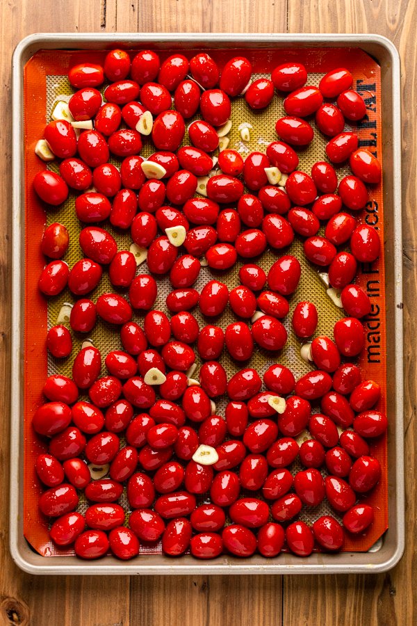 tomatoes and garlic on a baking sheet