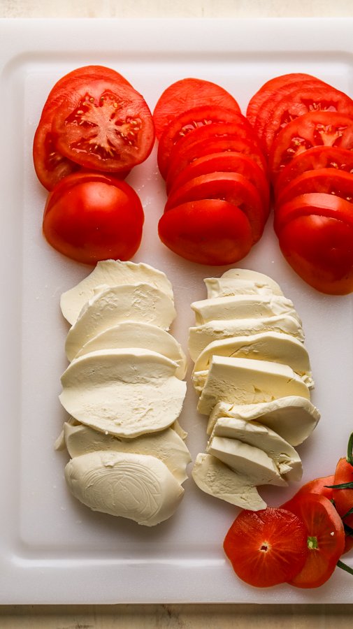 tomatoes and cheese on a white cutting board